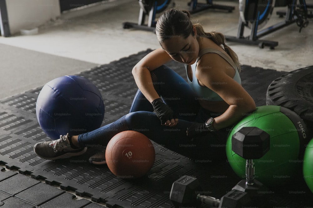 a woman sitting on the ground with a ball