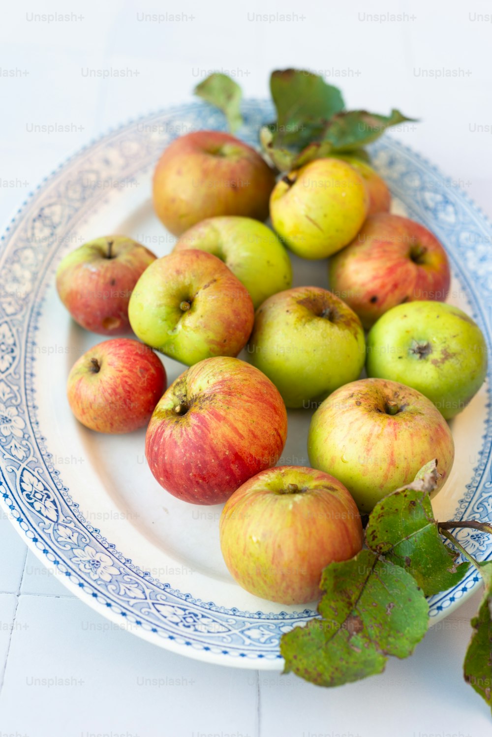 a white plate topped with lots of green and red apples