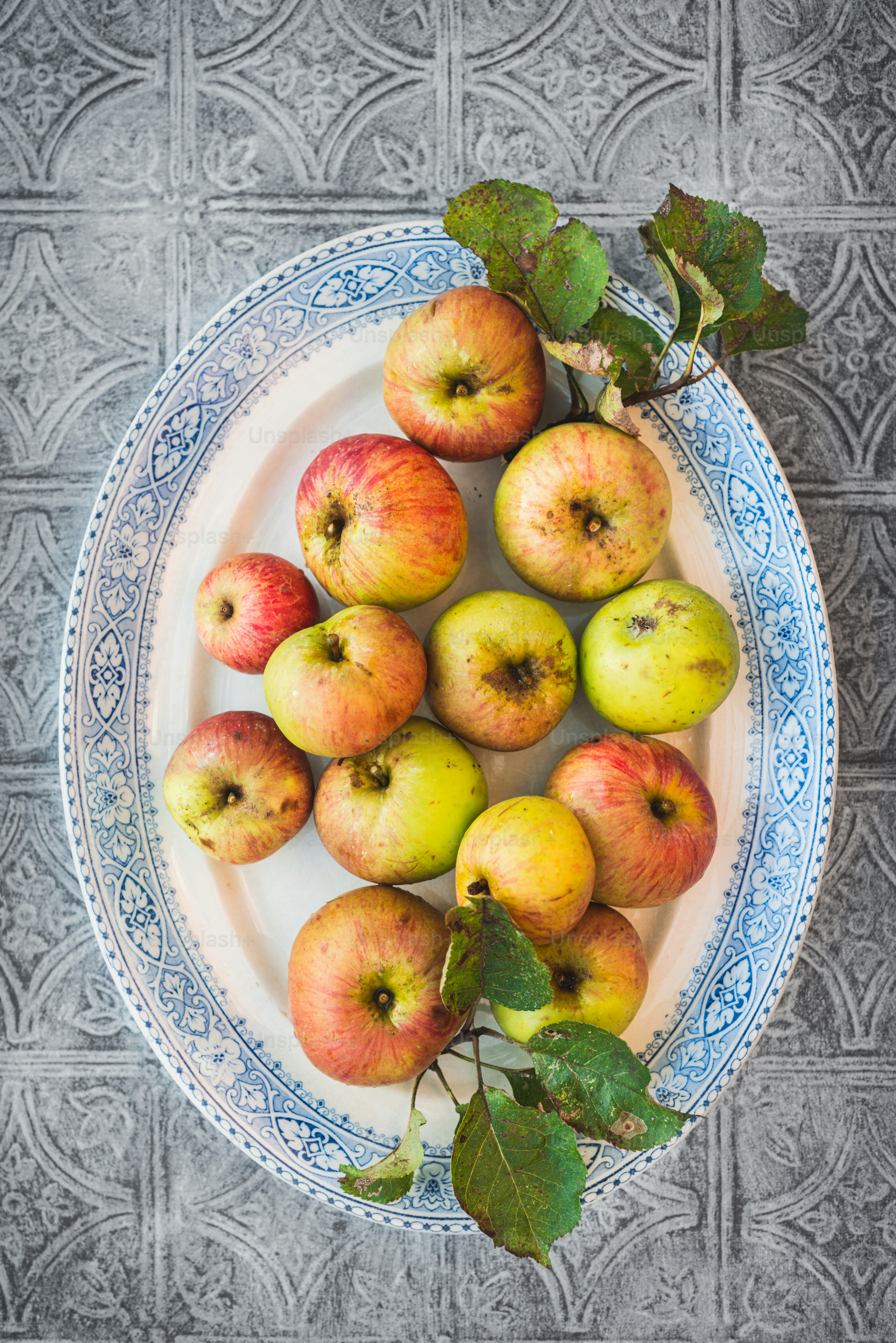 ein weißer Teller mit vielen Äpfeln