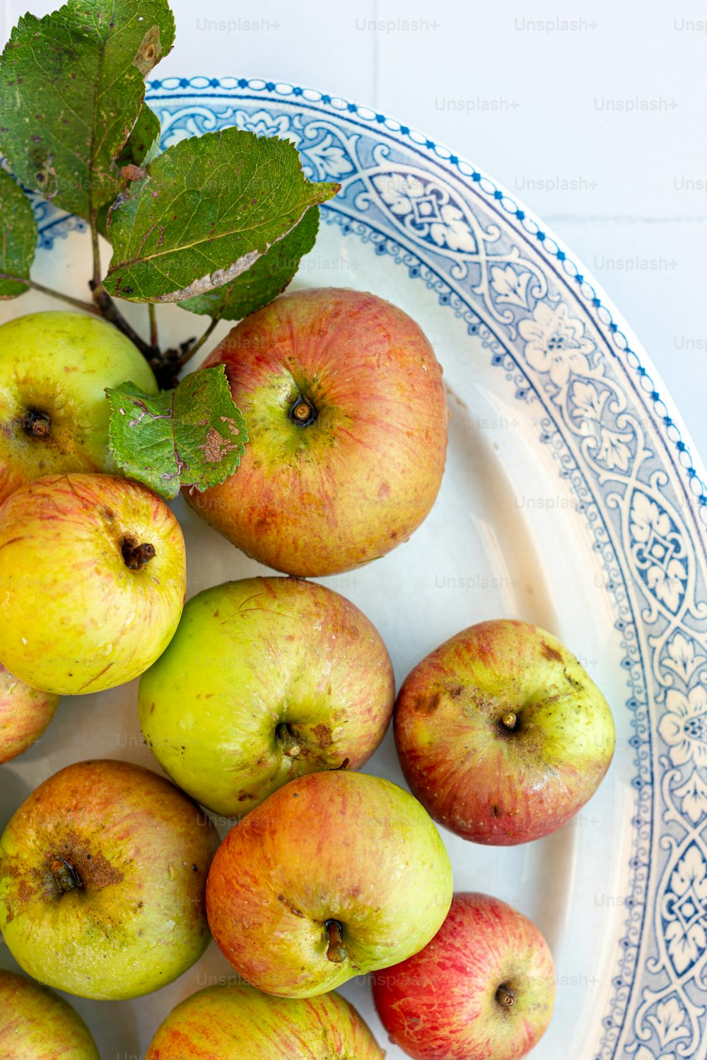 une assiette blanche surmontée de beaucoup de pommes vertes et rouges