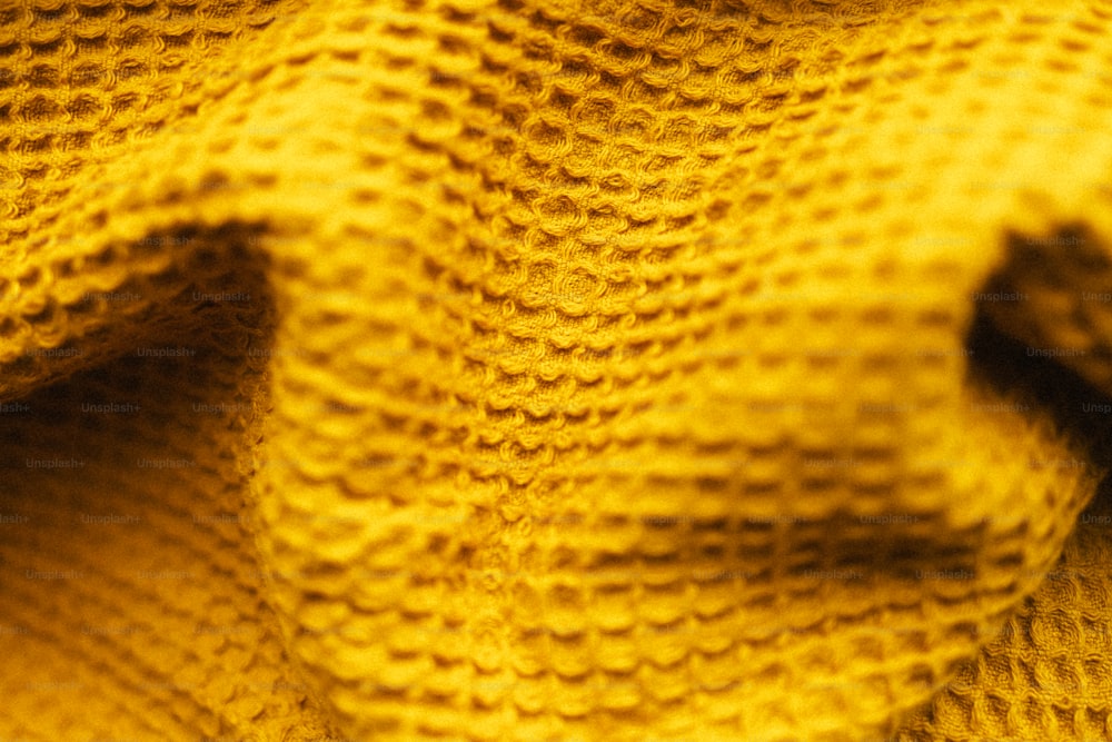 a close up of a yellow knitted sweater