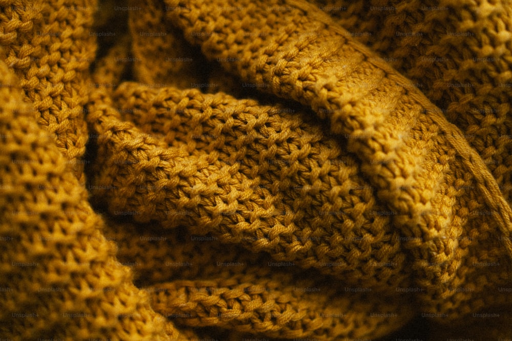 a close up of a yellow knitted blanket