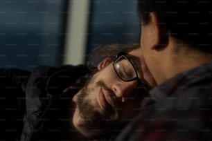 a man with glasses laying down next to another man