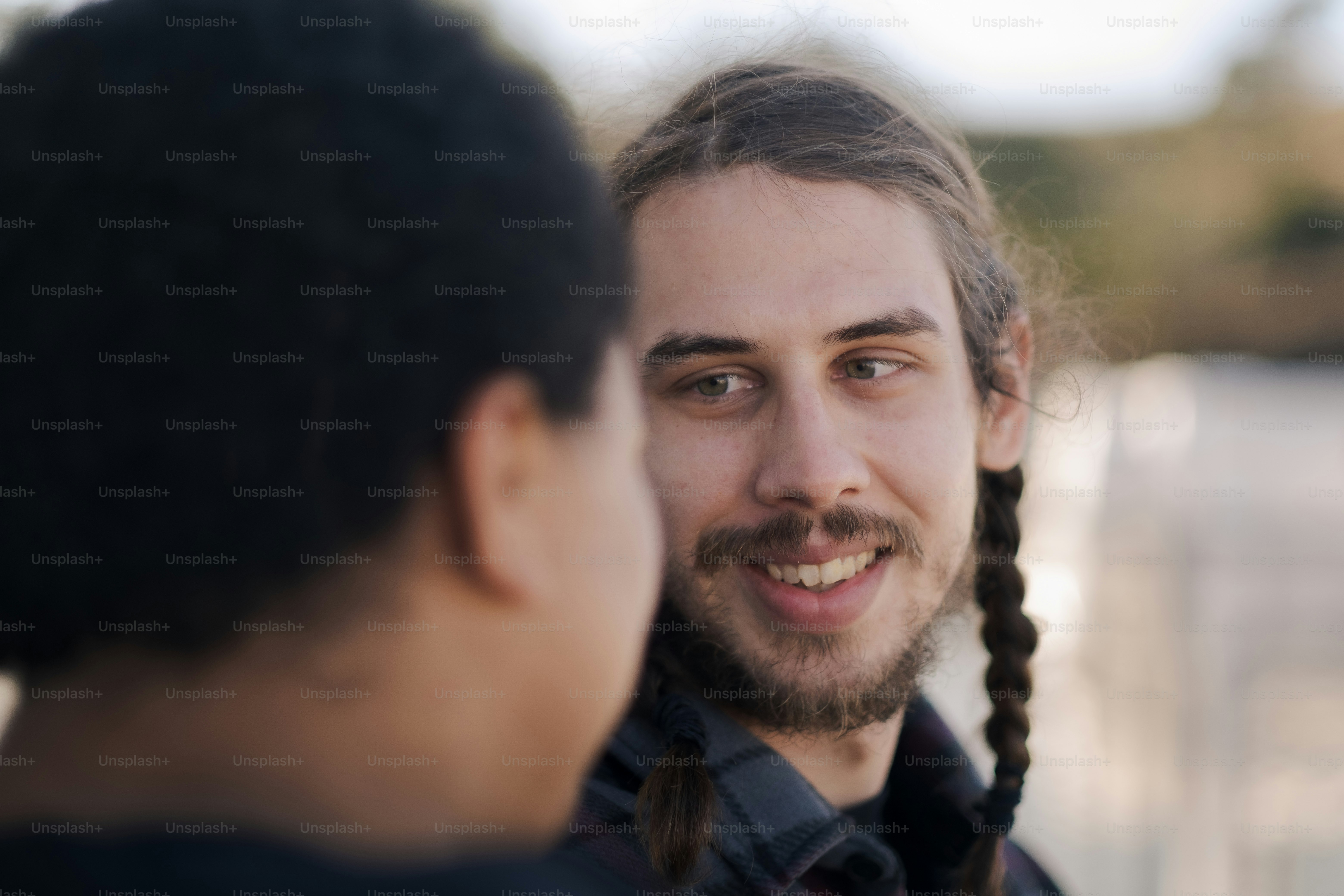 a man with long braids is looking at another man