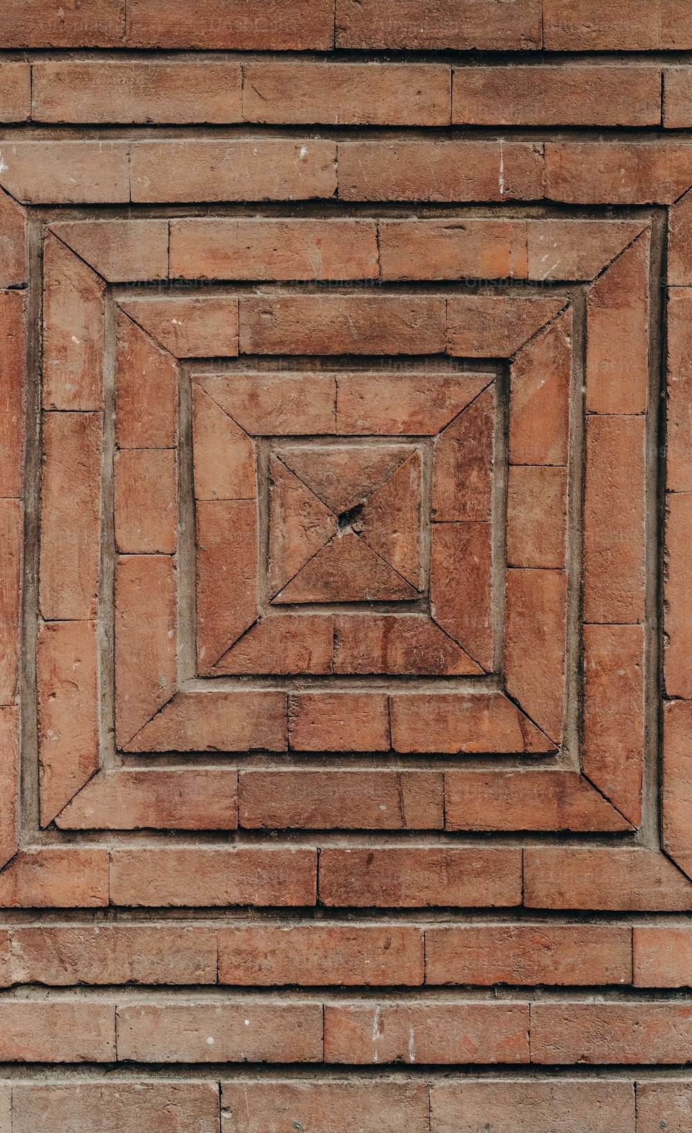 un mur de briques avec un design carré au centre