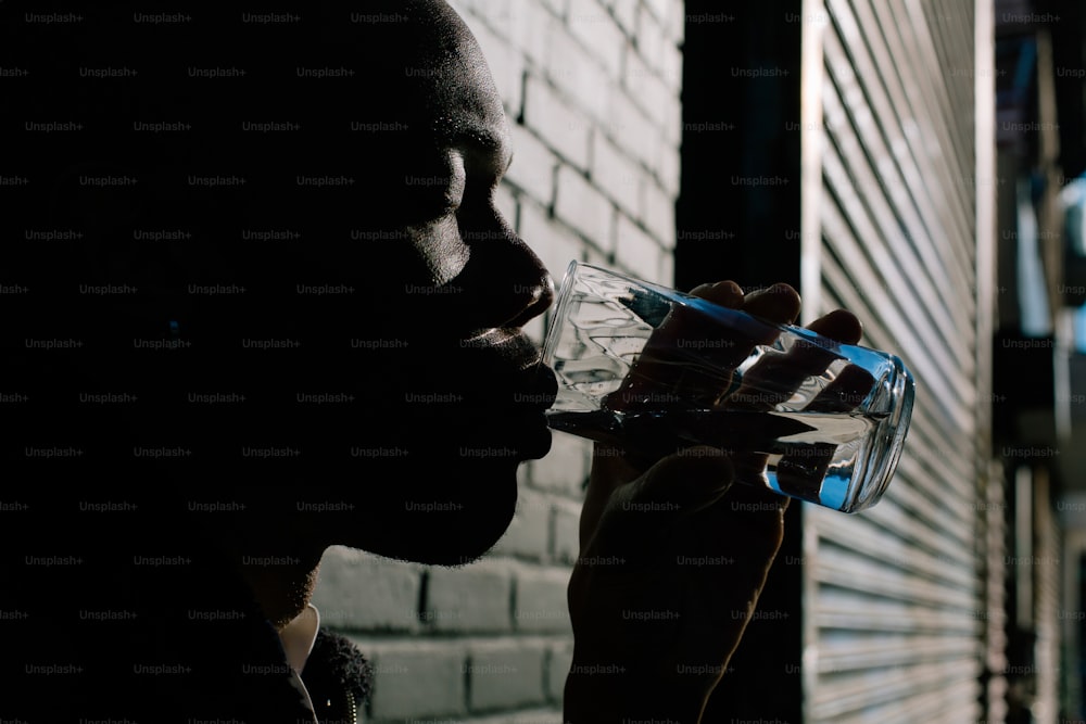 a man drinking water out of a glass