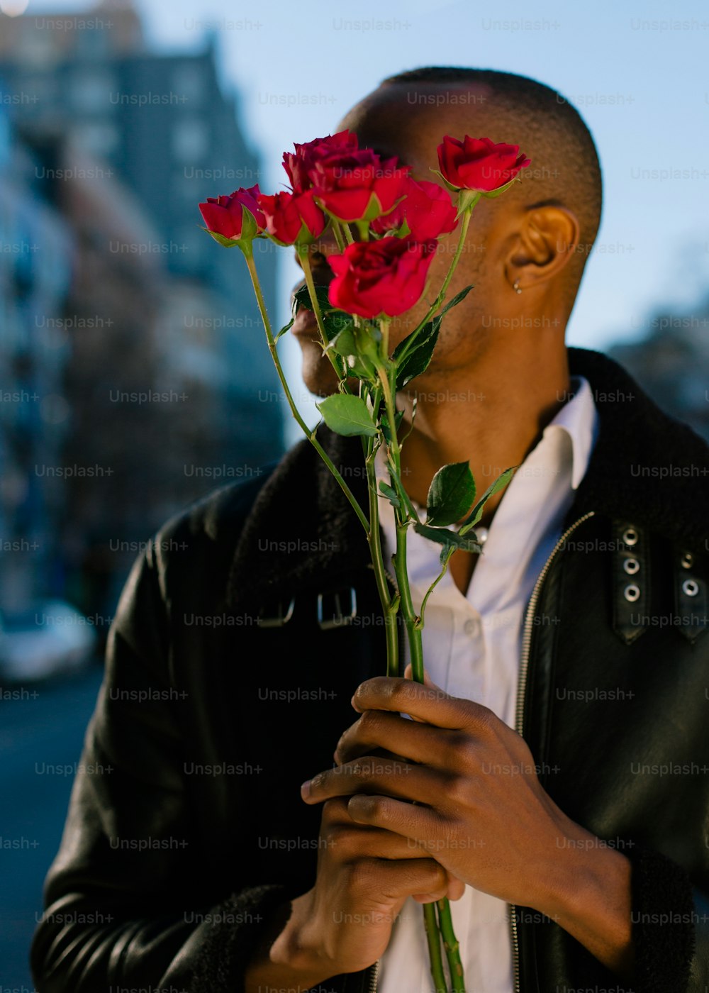 um homem segurando um monte de rosas vermelhas