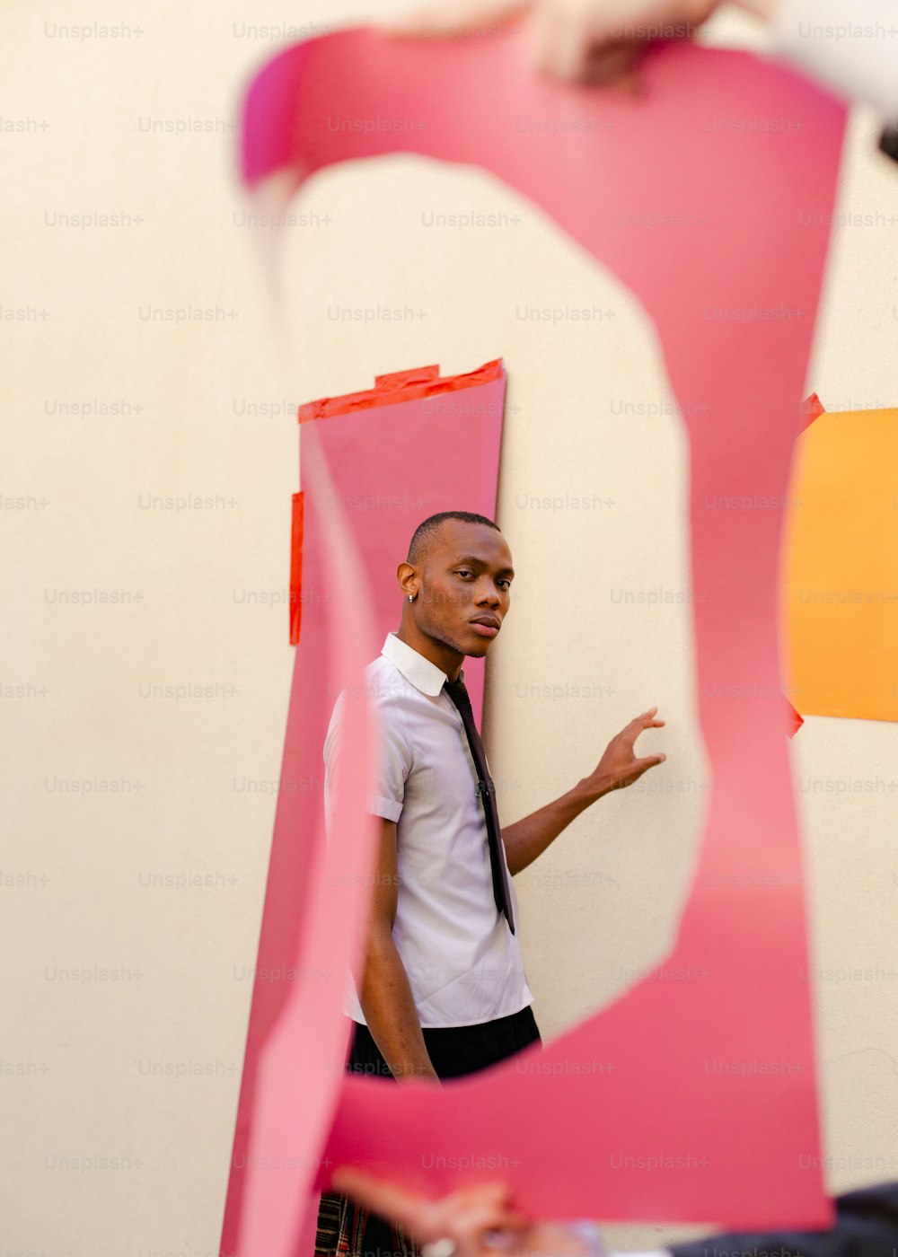 a man standing in front of a pink sculpture