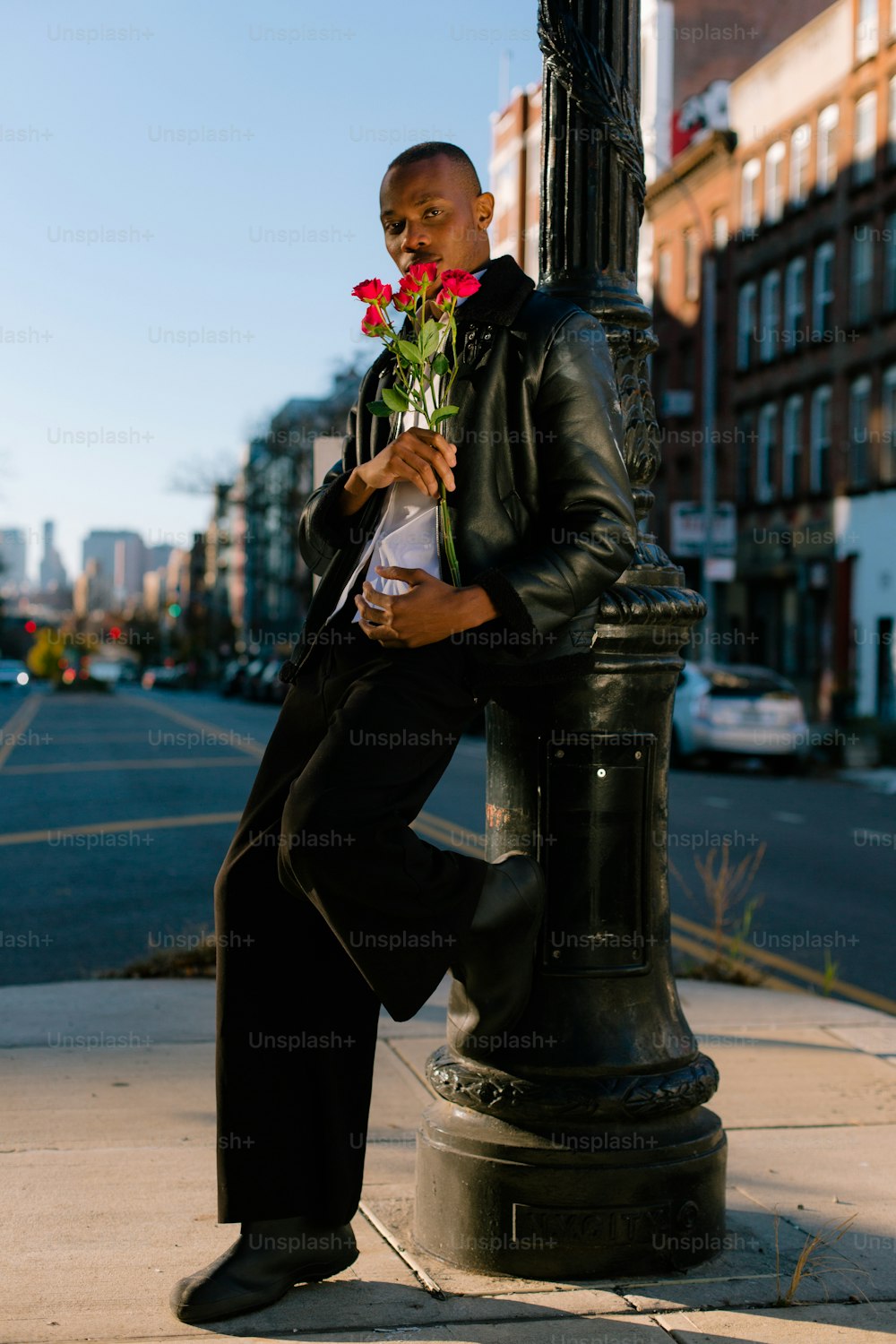 a man sitting on a pole with a flower in his hand