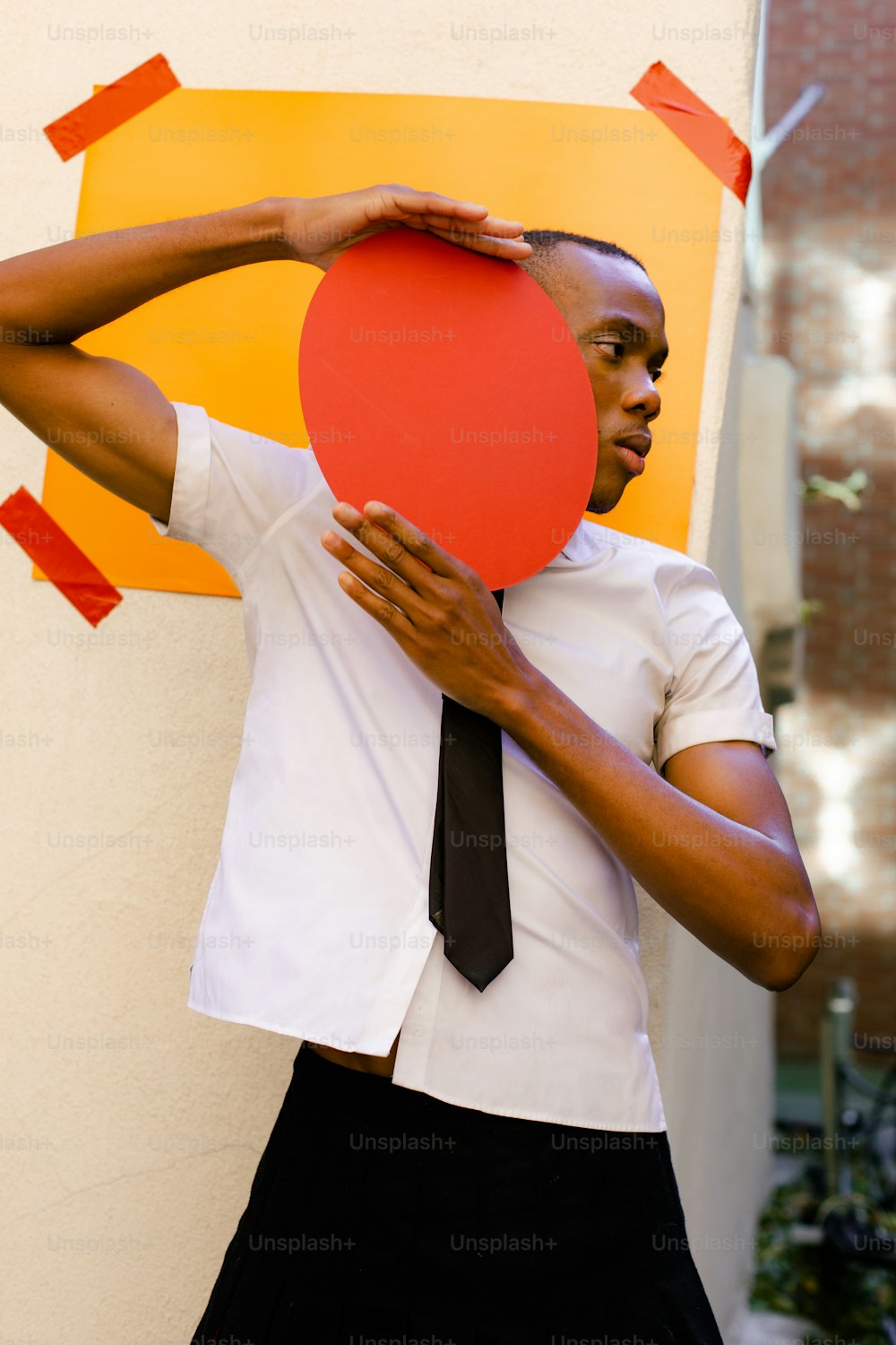 a man in a tie holding a paper heart