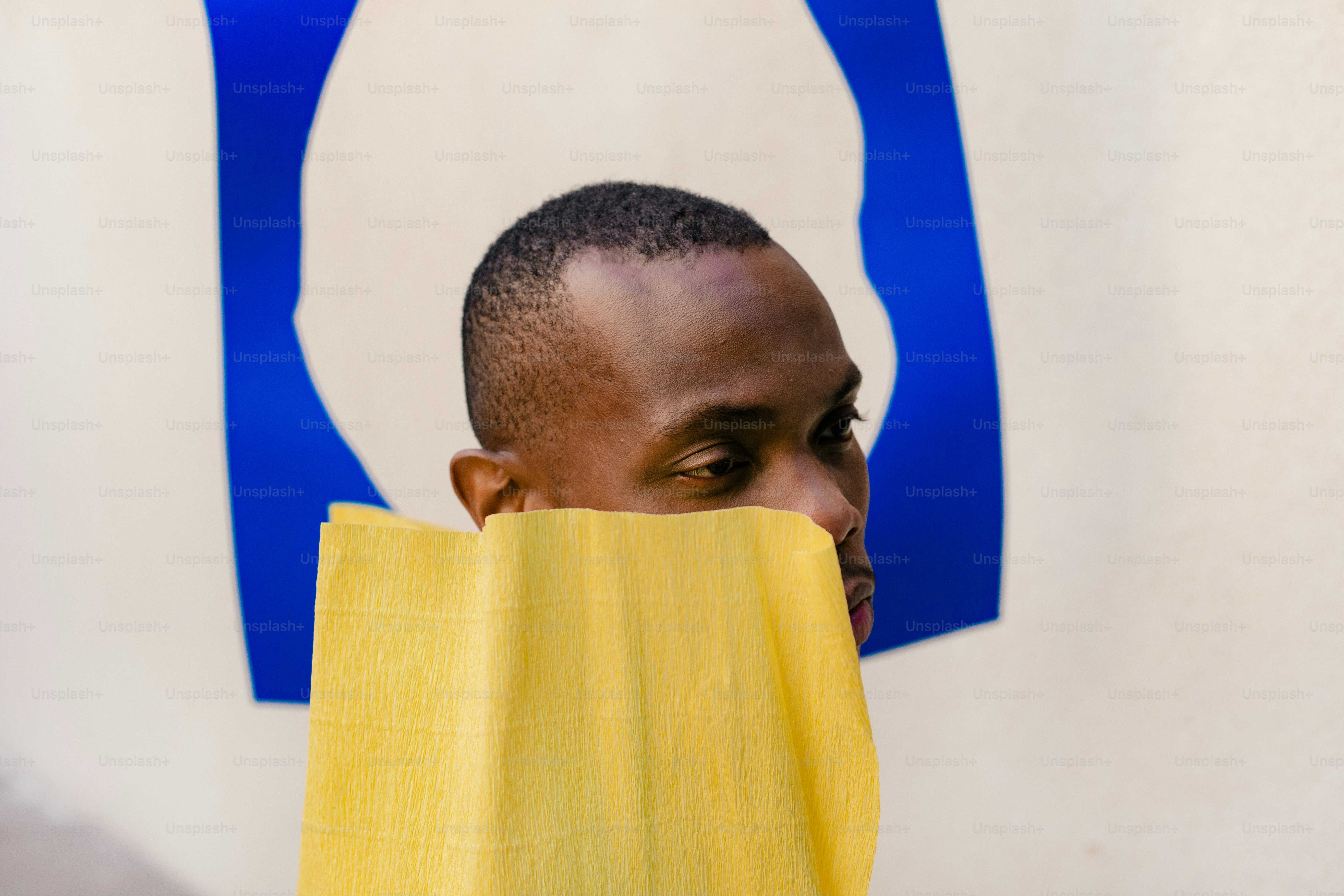 a man with a yellow towel covering his face