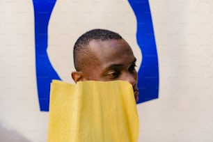 um homem com uma toalha amarela cobrindo o rosto