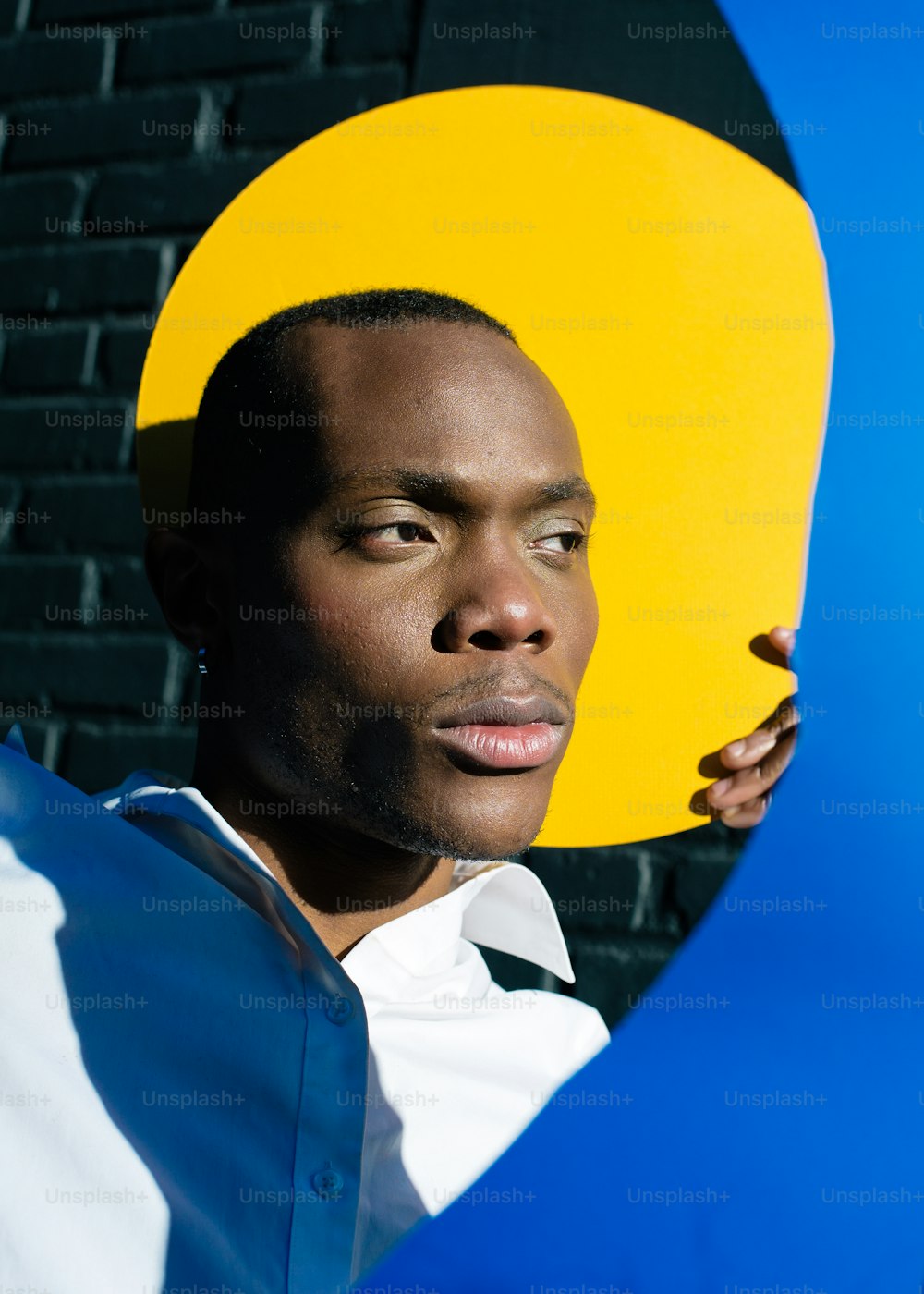 um homem segurando um grande objeto amarelo e azul