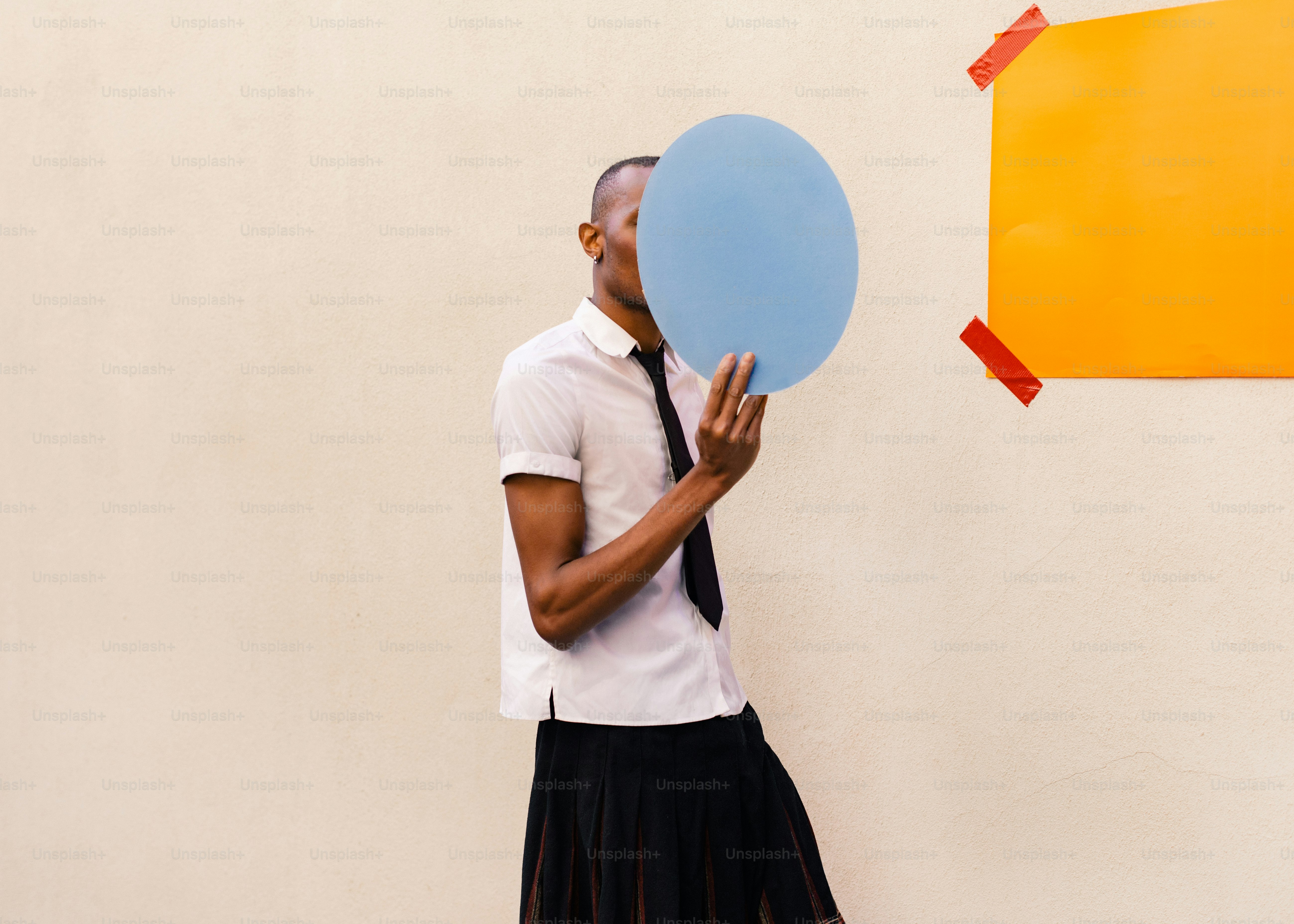 a man holding a blue balloon in front of a wall