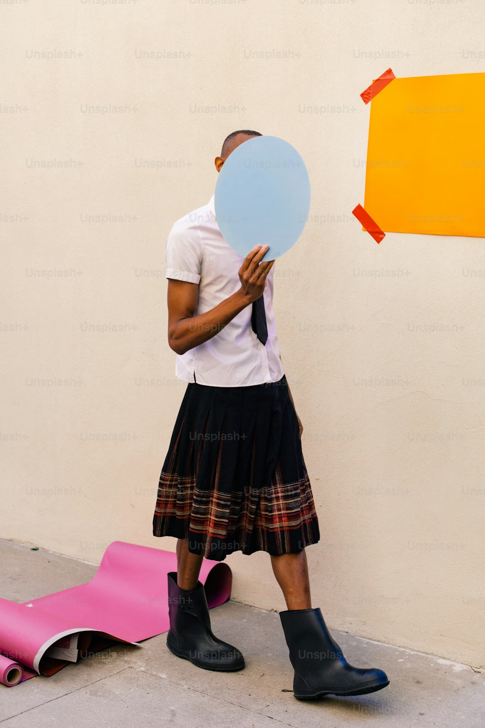 a man in a skirt holding a blue balloon