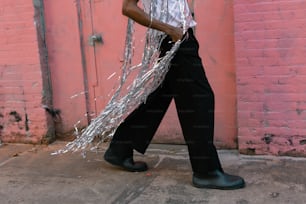 a woman walking down a street carrying a bunch of tinsel
