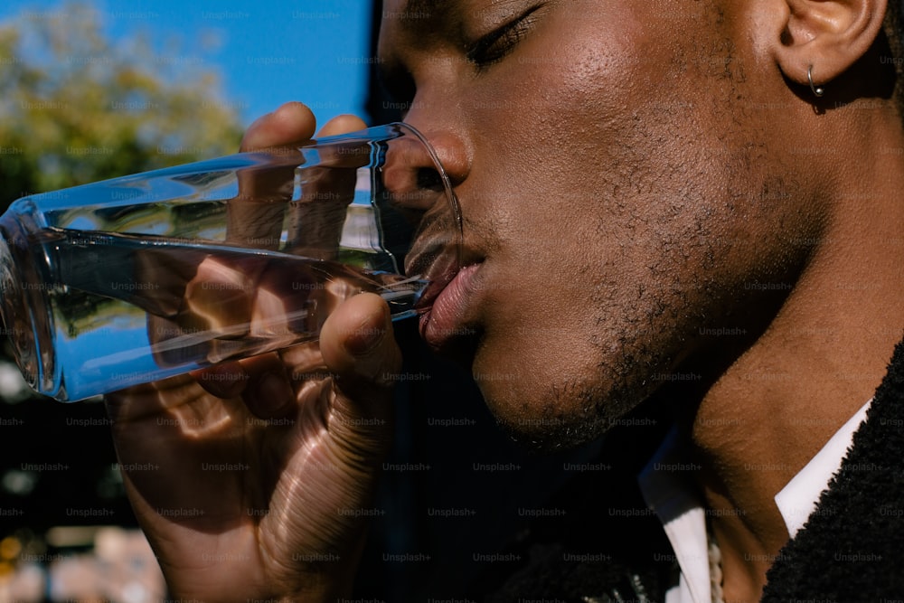 a man drinking from a glass of water