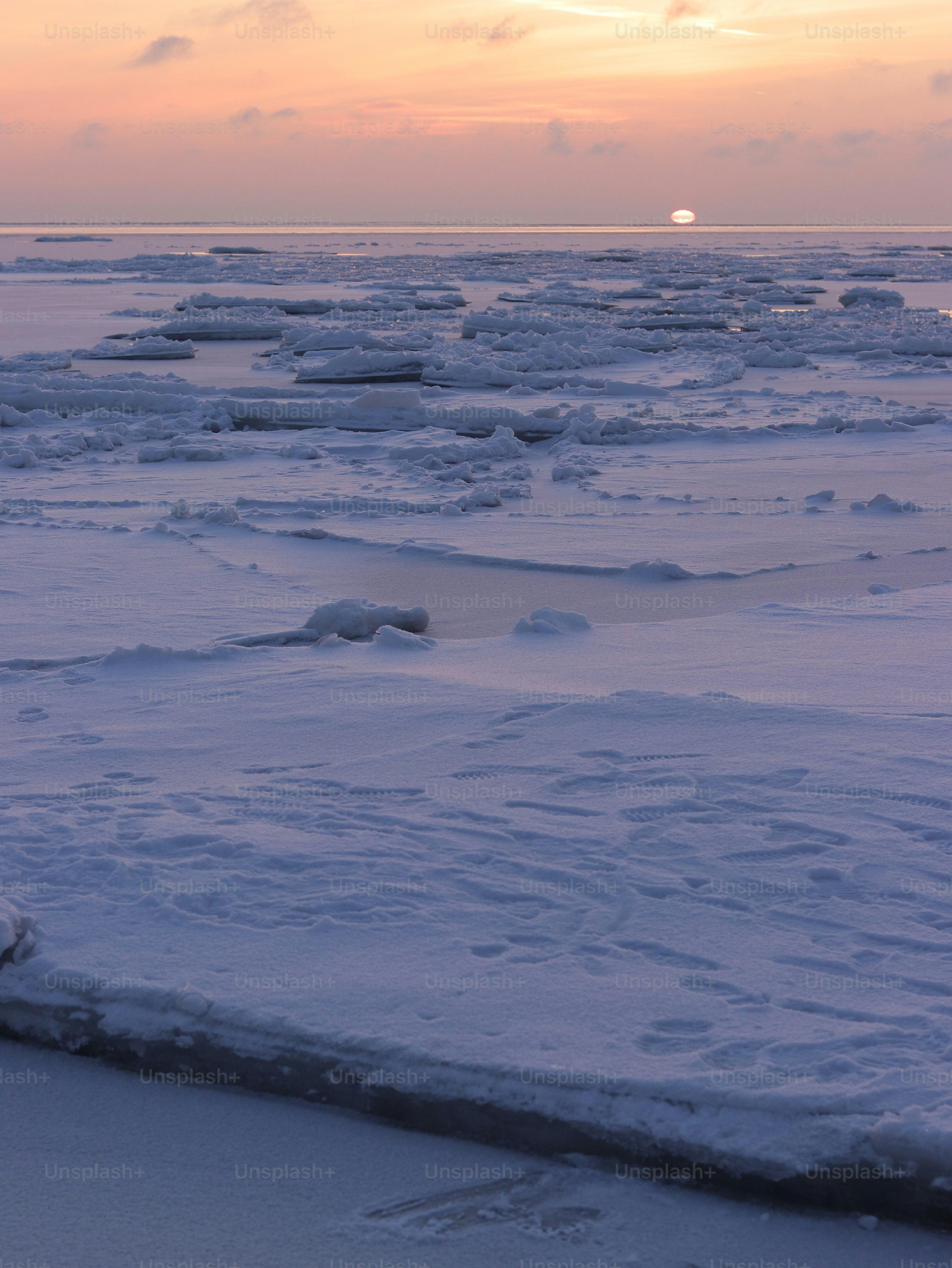 a person riding a surfboard on top of a snow covered beach