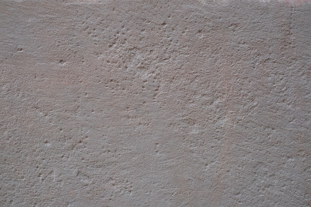 a close up of a cement wall with small holes in it