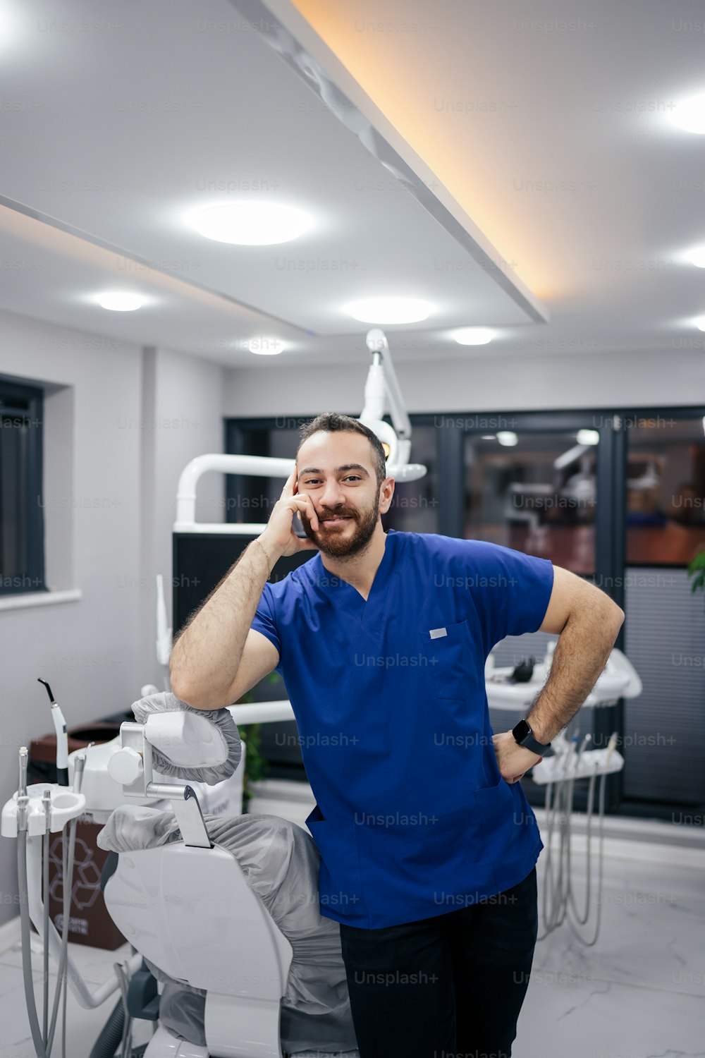 Un uomo nello studio di un dentista che parla al cellulare