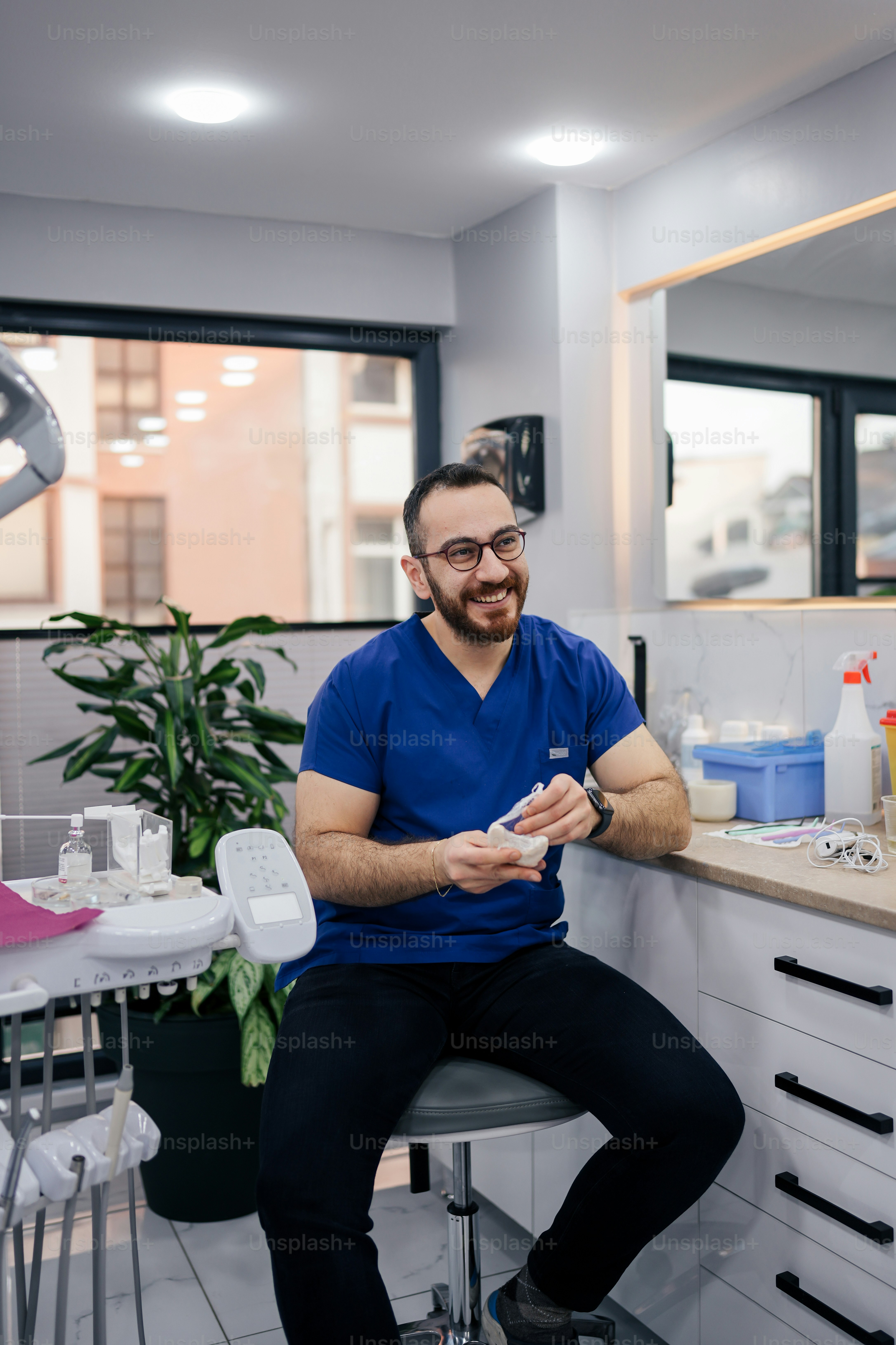 Un hombre sentado en un taburete en el consultorio de un dentista