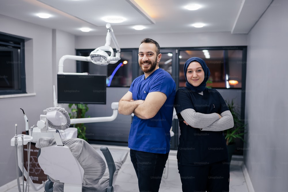um homem e uma mulher em pé na frente da cadeira de um dentista
