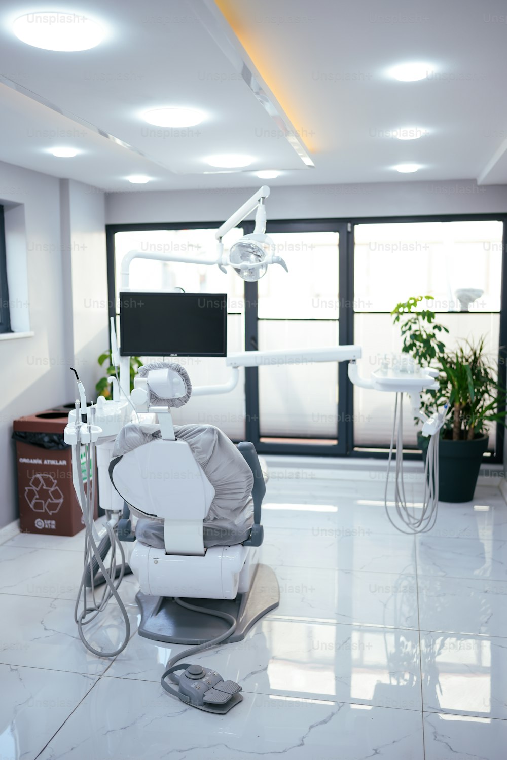 a dentist chair sitting in a room next to a window