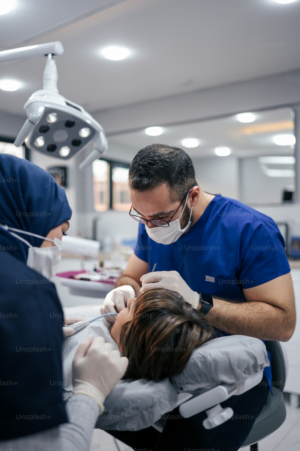 Ein Mann auf einem Zahnarztstuhl lässt sich die Zähne untersuchen