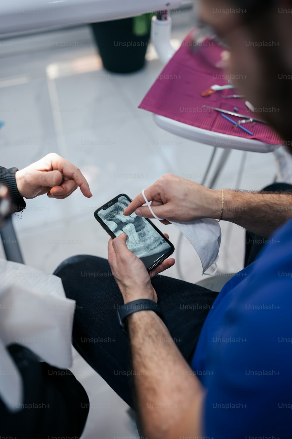 a man sitting on a chair holding a smart phone