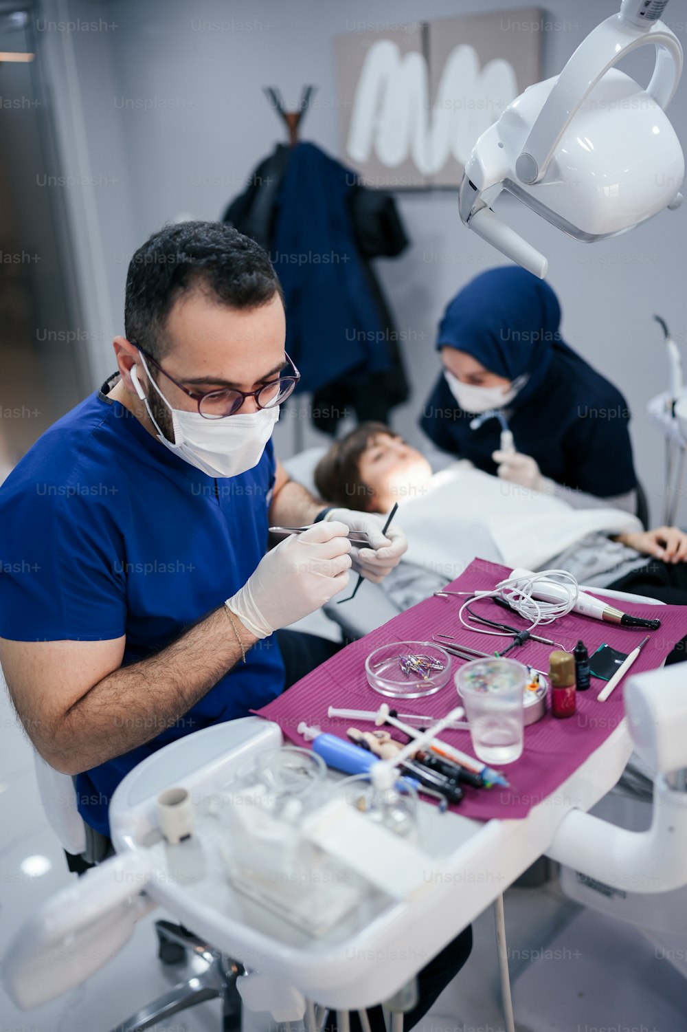 Un uomo seduto su una poltrona del dentista mentre indossa una maschera