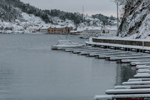 a row of boats sitting on top of a lake covered in snow