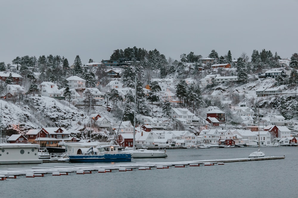 Una montaña cubierta de nieve con casas y barcos en el agua