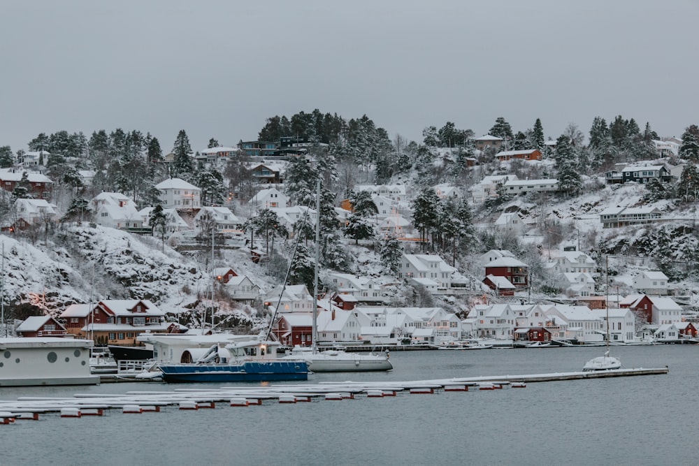 a snow covered mountain with houses and boats in the water