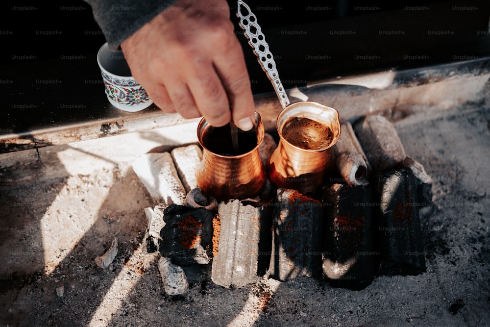 a person is pouring something into a metal container