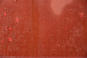 eine rote Wand mit Wassertropfen darauf