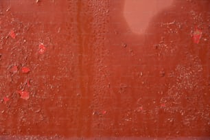 a red wall with drops of water on it