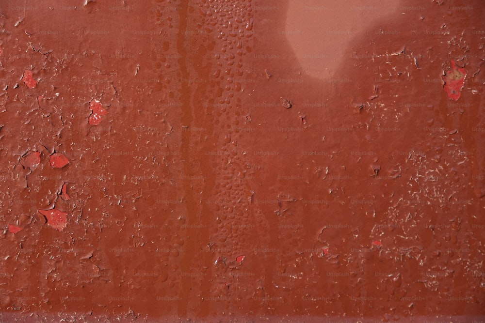a red wall with drops of water on it