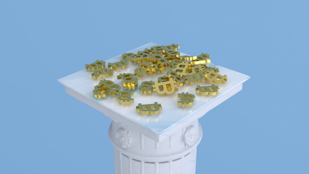 a pile of gold numerals sitting on top of a white pedestal