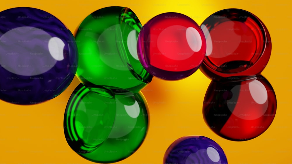 Un grupo de coloridas bolas de vidrio sobre un fondo amarillo