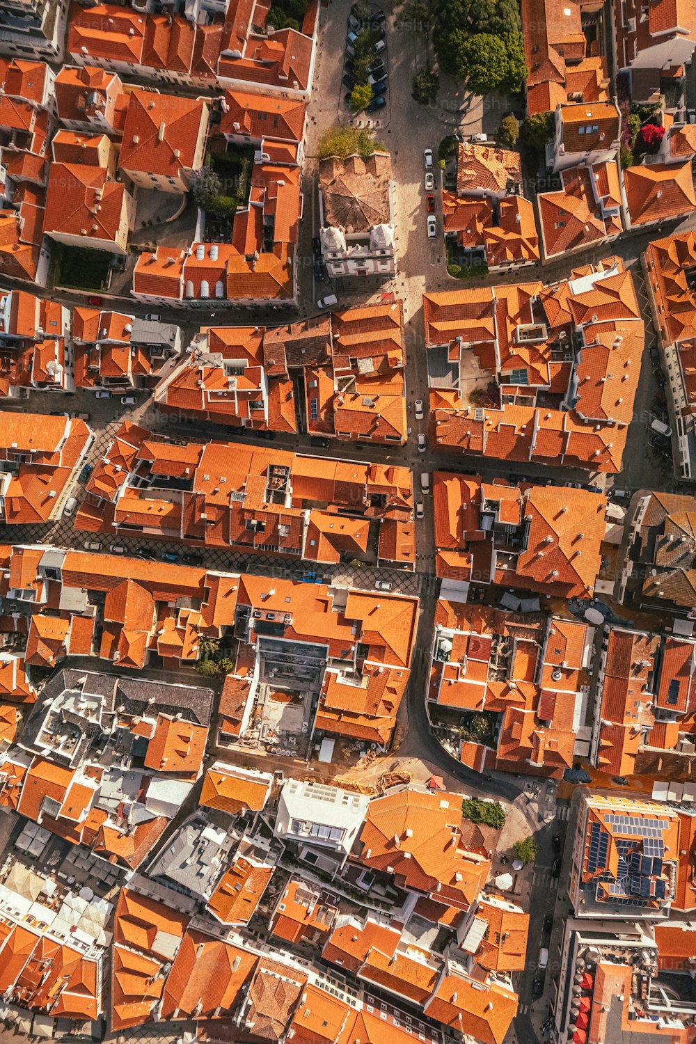 an aerial view of a city with orange roofs