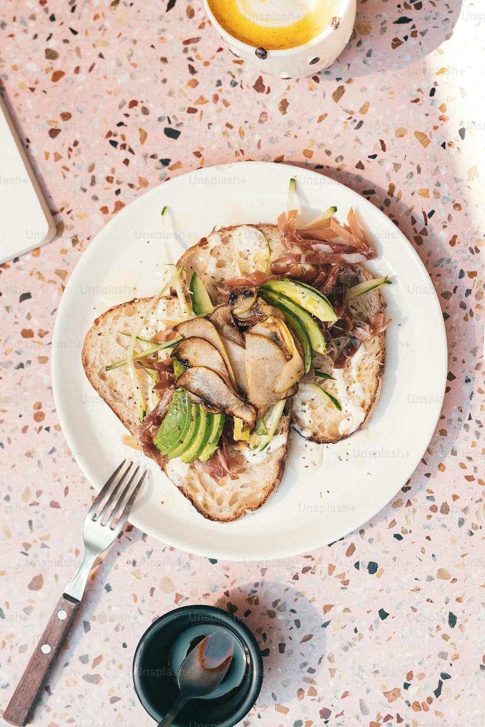 a plate of food on a table next to a cup of coffee