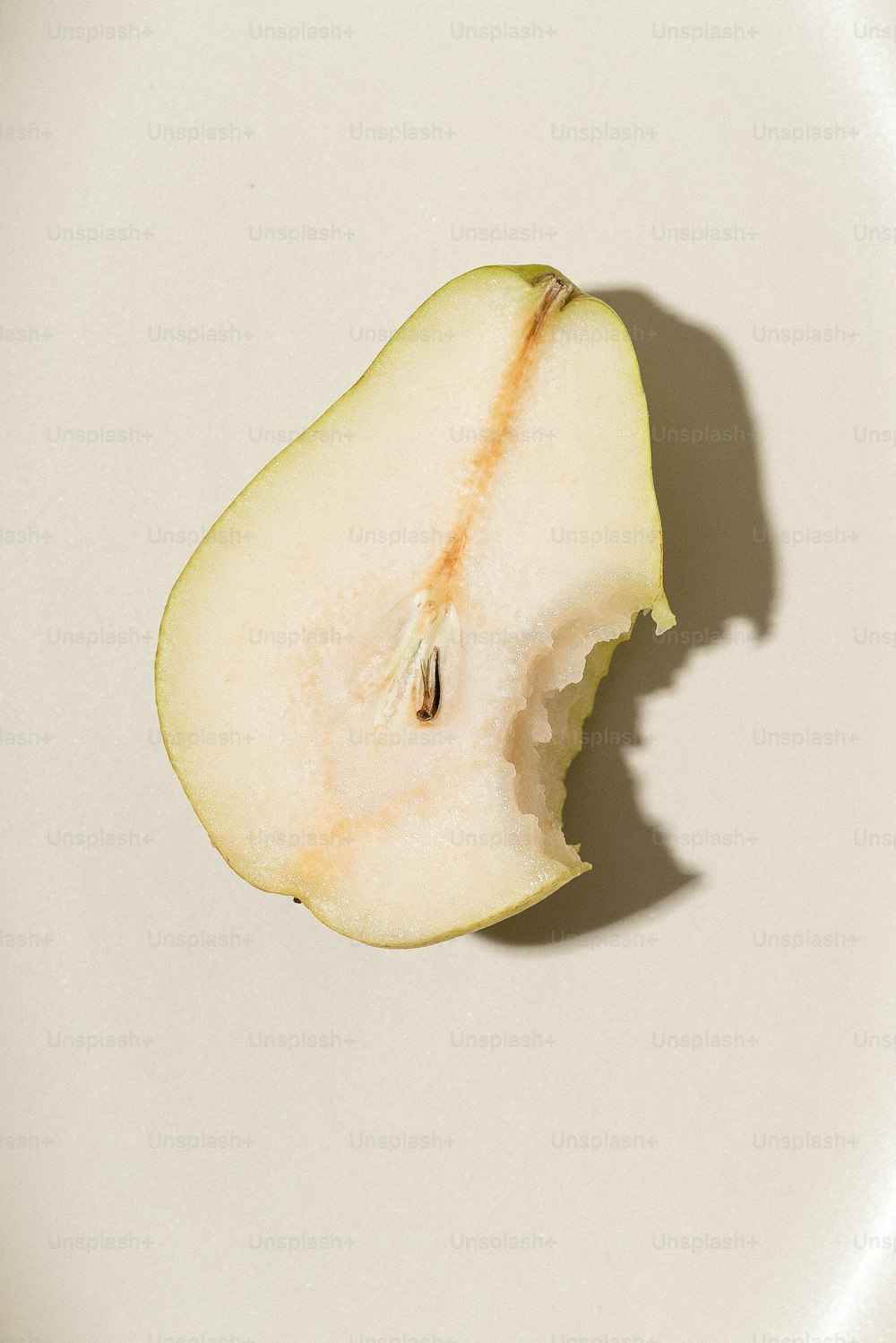 uma maçã meio comida sentada em cima de um prato branco