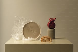 un tavolo bianco sormontato da un piatto e un vaso