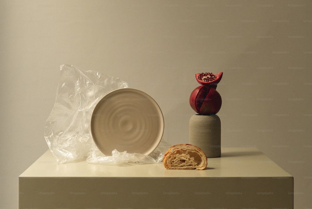 une table blanche surmontée d’une assiette et d’un vase