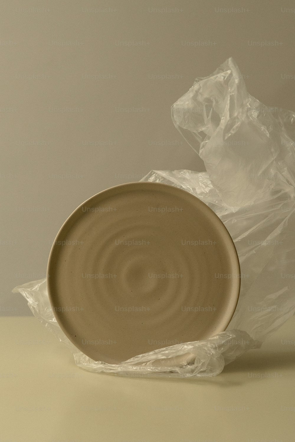 a brown plate sitting on top of a plastic bag