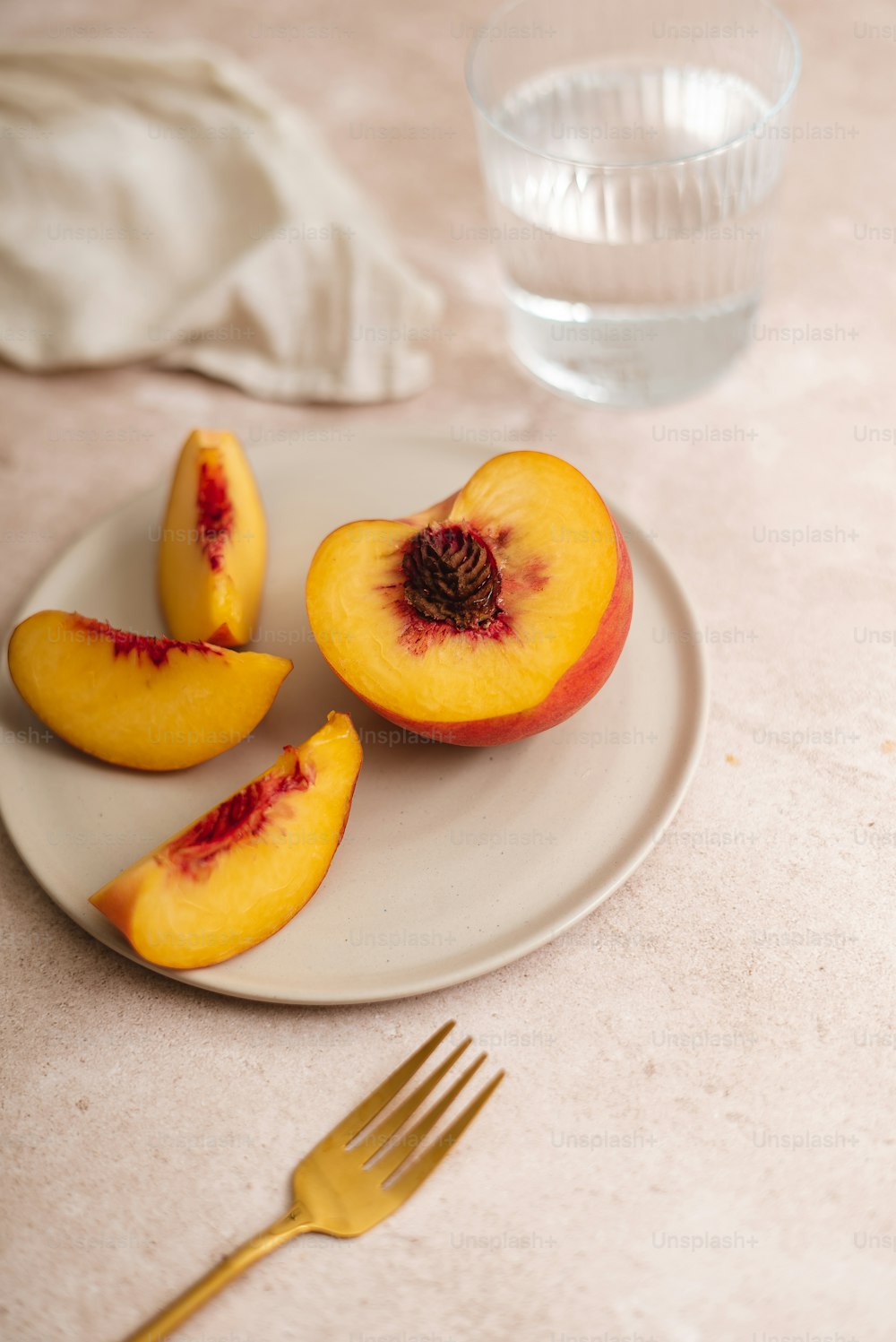 a white plate topped with sliced peaches next to a fork