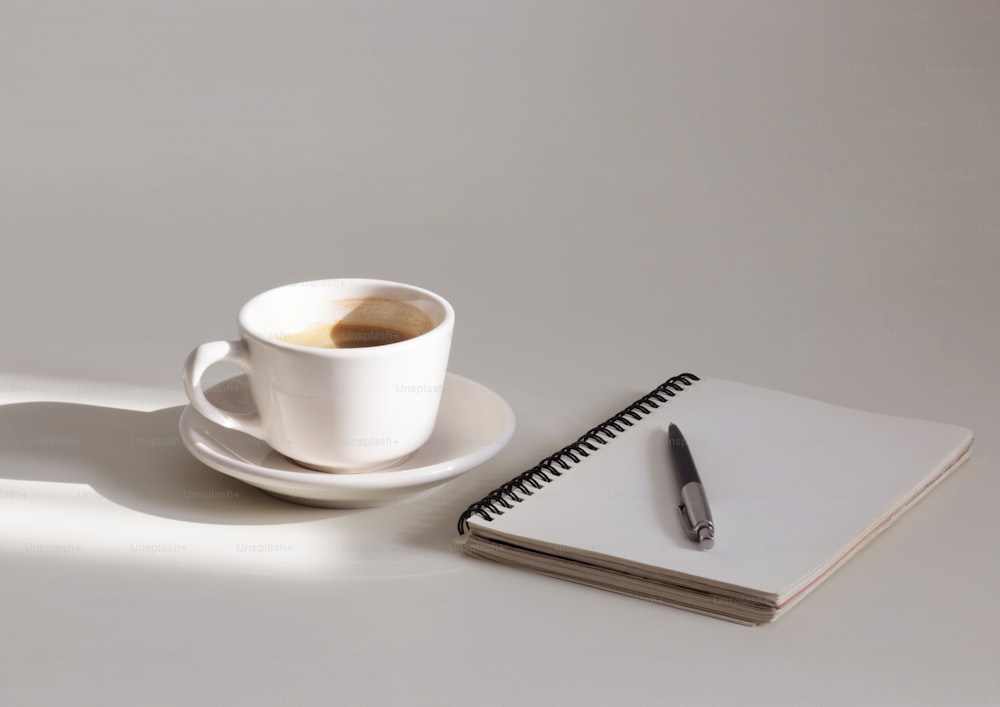 une tasse de café et un cahier sur une table