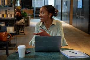 ノートパソコンを持ってテーブルに座っている女性