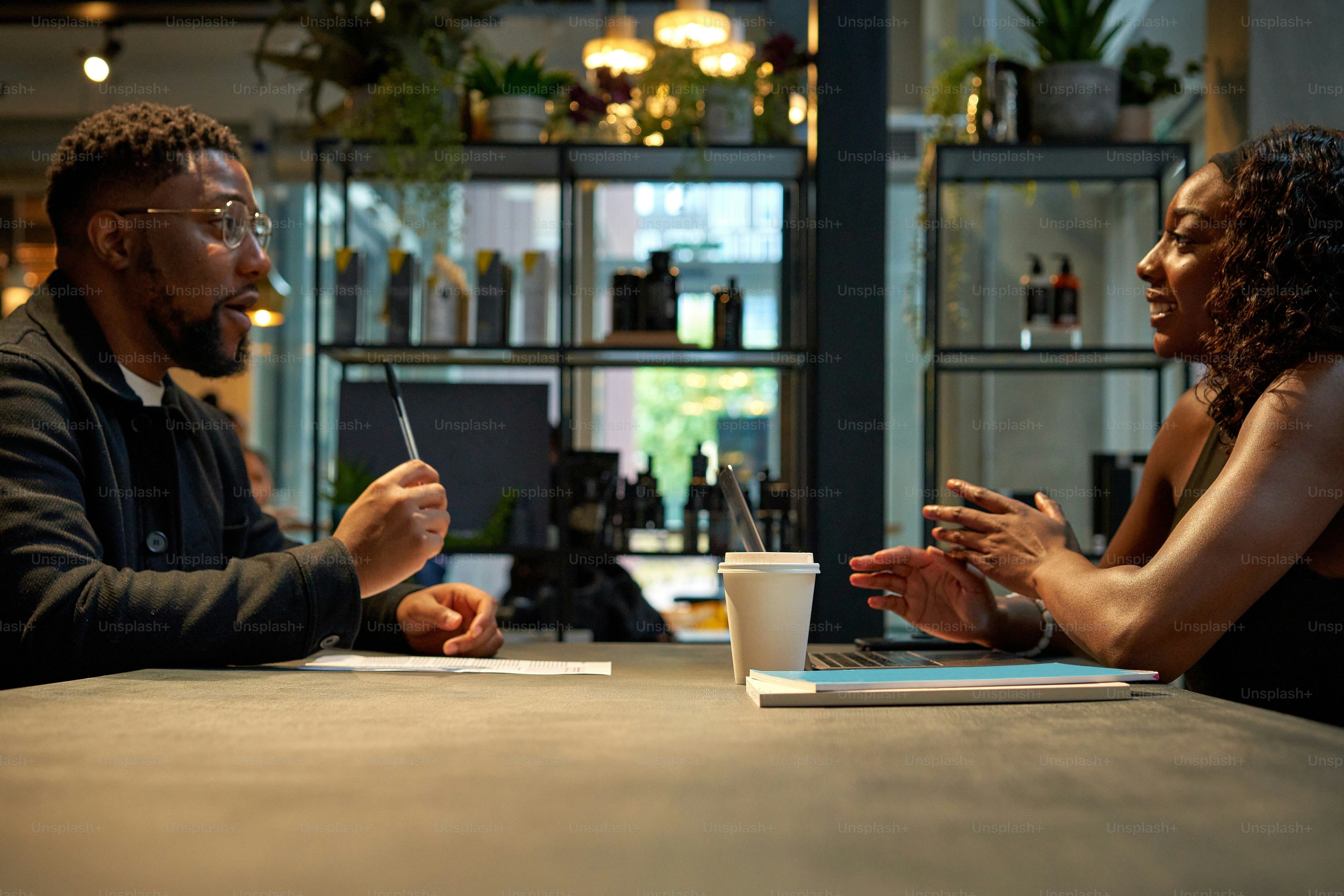 Un hombre y una mujer sentados en una mesa hablando
