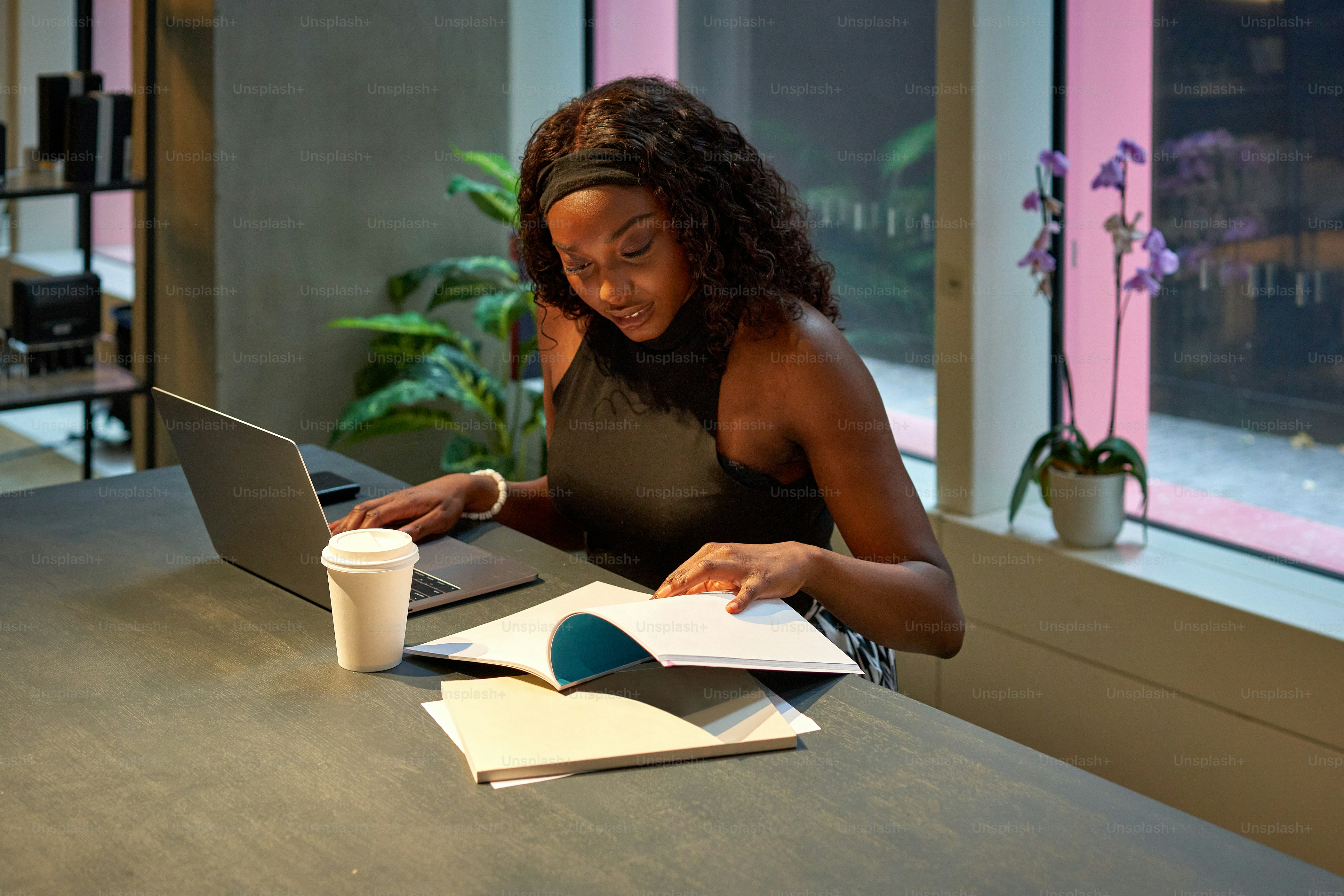 Una mujer sentada en una mesa trabajando en una computadora portátil